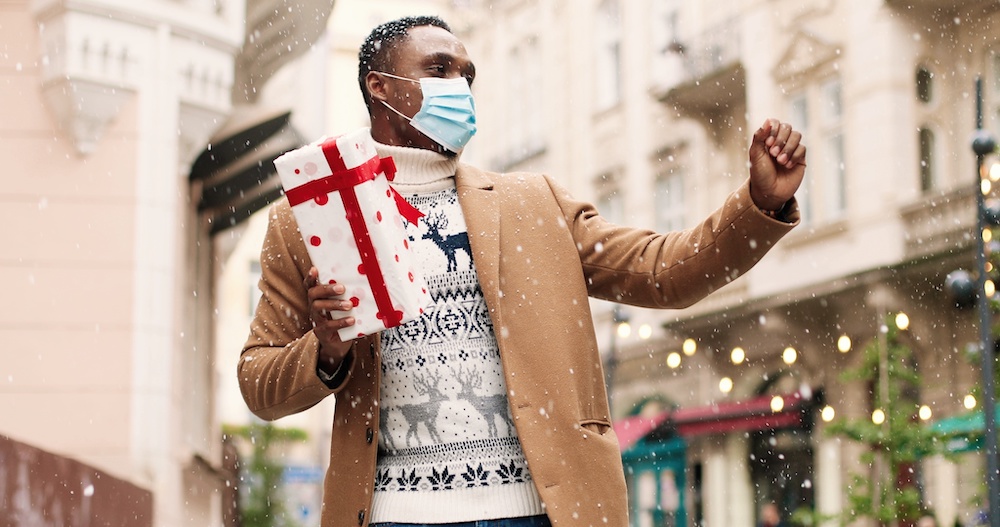 mask with holiday presents moving on street.