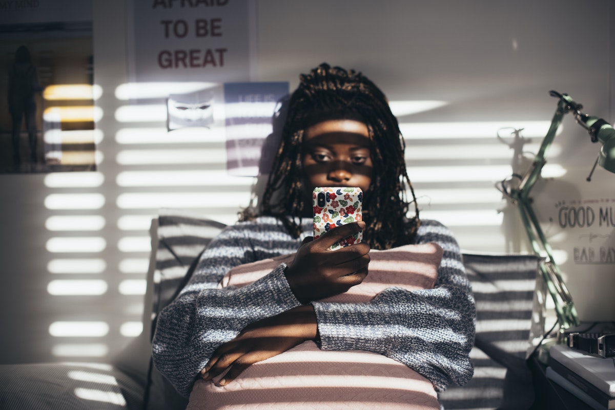 Girl using her phone in bed