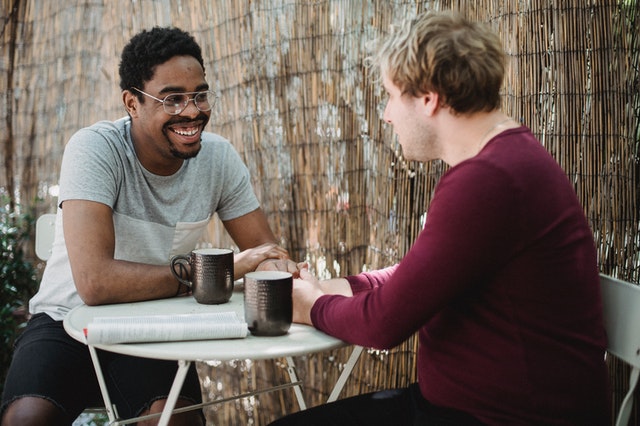 two-men-having-coffe-sitting-table-talking