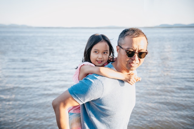 father-giving-his-daughter-a-piggy-back-ride-on-the-beach-anxiety-children
