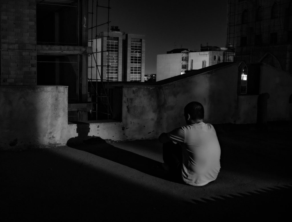 lonely man sitting on rooftop at night Disorganized Thinking and Speech from Schizophrenia