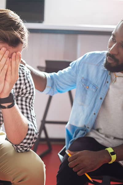 Man consoling his peer during Schizoaffective Disorder Treatment’s group therapy session. Man consoling his peer during Schizoaffective Disorder Treatment's group therapy session.