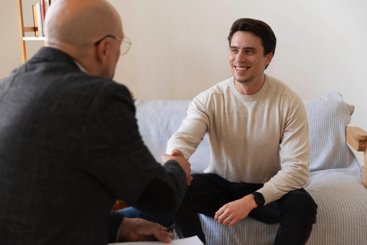 Two men sitting across from each other in what appears to be a therapy or counseling session