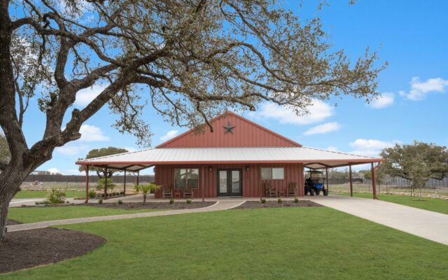 Exterior of a red-roofed single-story building surrounded by green lawn and trees