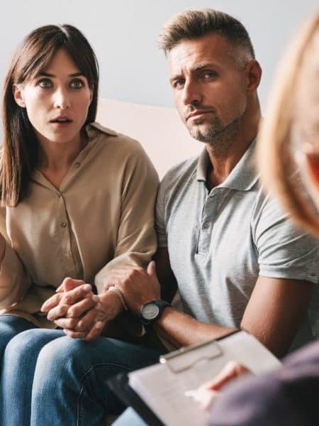 Two people in a clinical or counseling setting reviewing documents together