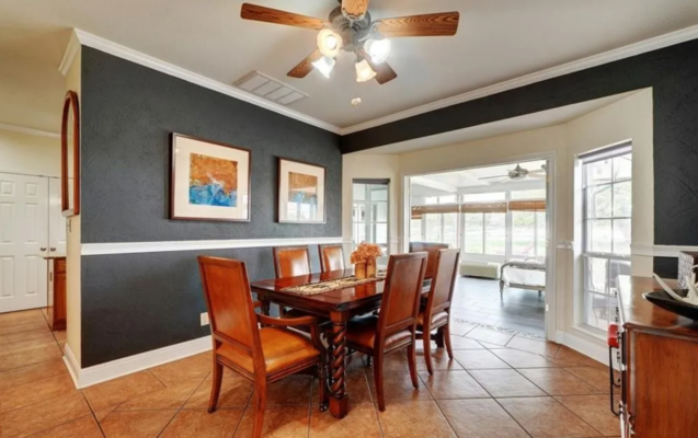 Dining room with wooden furniture, warm overhead lighting, and a ceiling fan