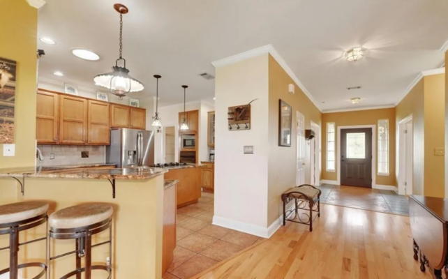 Bright open-concept living and kitchen area with hardwood floors and natural light