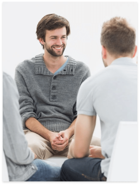 Two men sitting across from each other in a calm conversation or therapy session