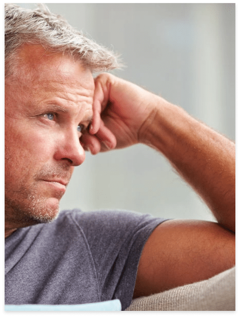 Man resting his head on his hand with a tired or emotionally heavy expression