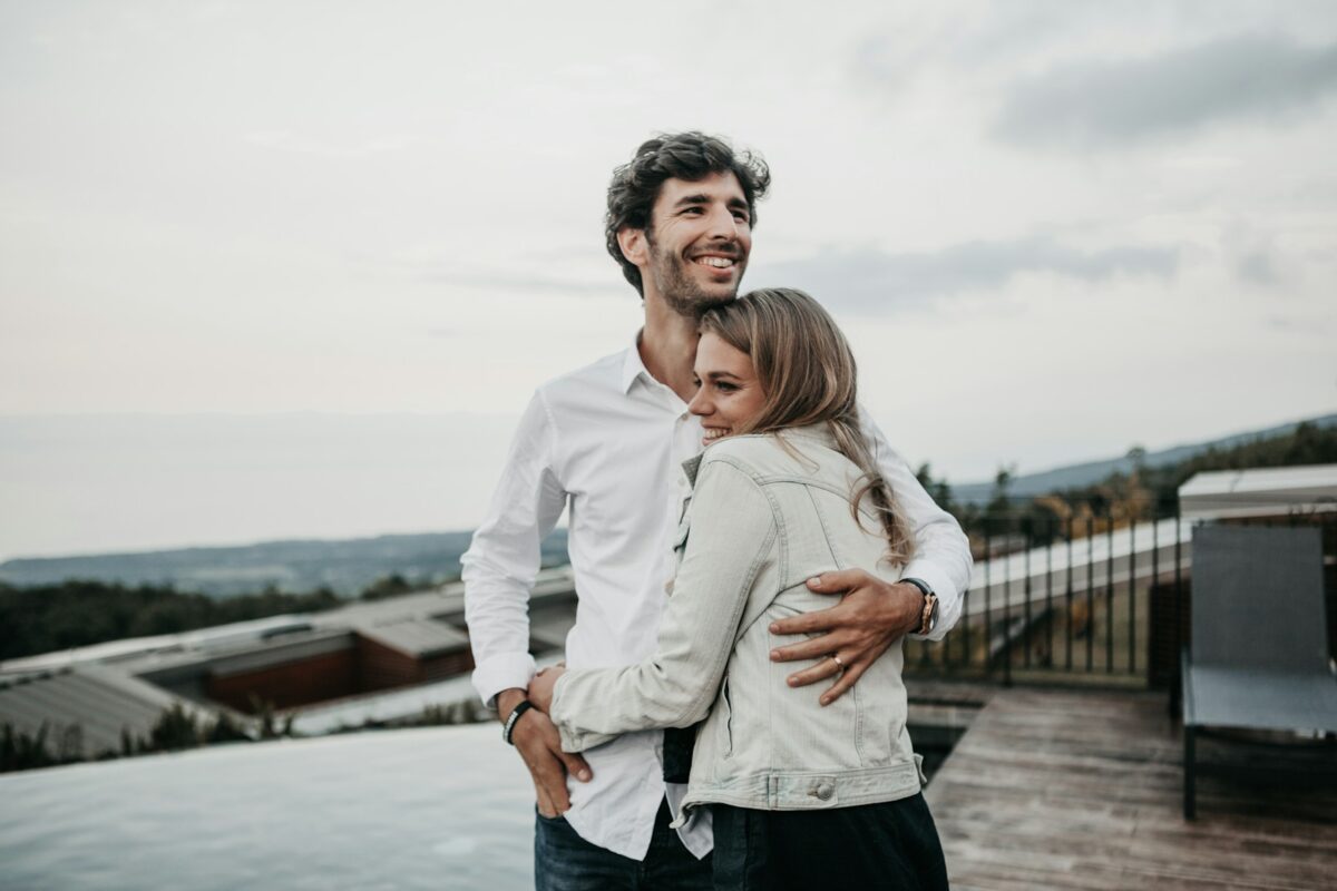 Man and woman laughing and embracing outdoors in a relaxed and joyful moment