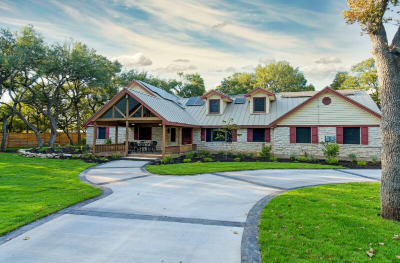Exterior of a single-story home with a wide driveway and well-maintained lawn