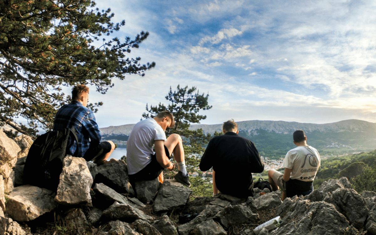 Group of people sitting together on rocks outdoors in a casual gathering