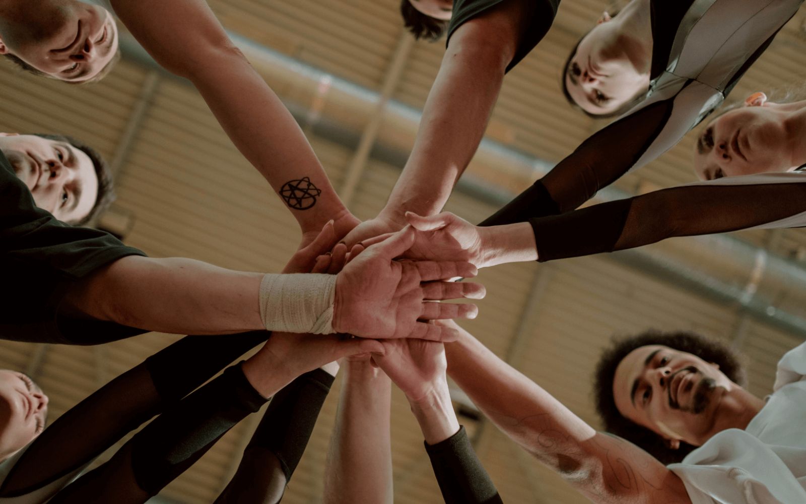 Group of diverse hands stacked together in a show of teamwork and solidarity