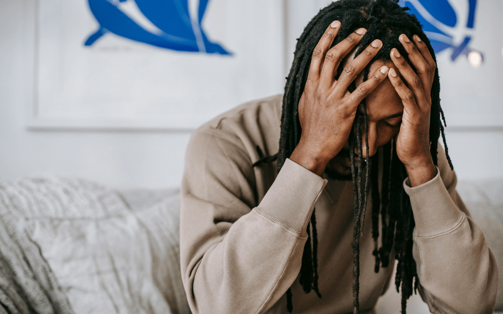 Man sitting on a couch with his head in his hands