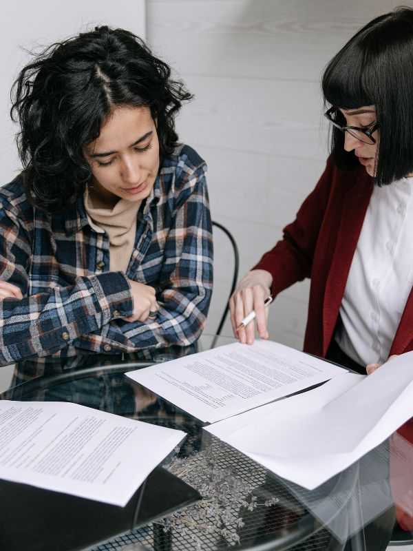 Woman sitting at a table reviewing documents in a counseling or meeting setting